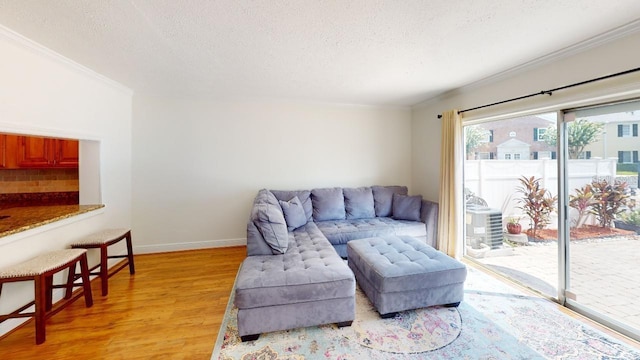 living room with ornamental molding, a textured ceiling, and wood-type flooring