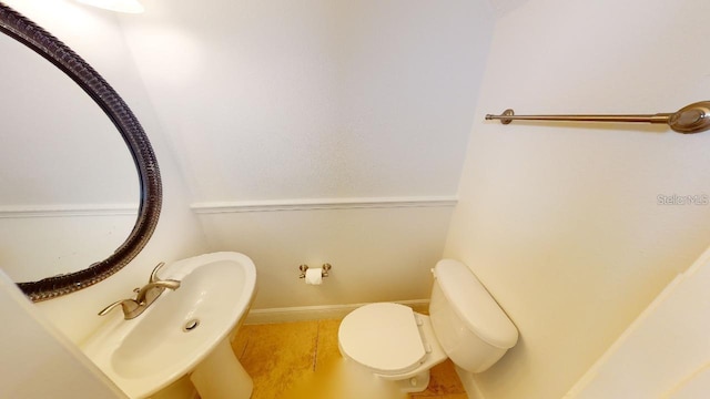 bathroom with tile flooring, sink, and toilet