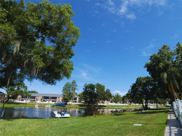 view of property's community featuring a lawn and a water view