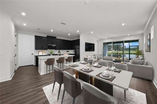 dining area featuring dark hardwood / wood-style floors, ornamental molding, and sink