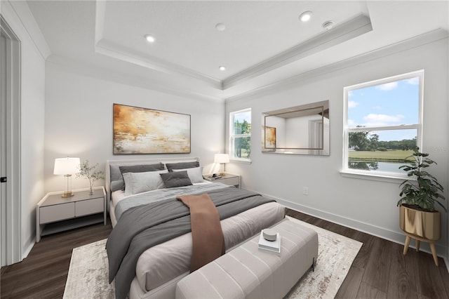 bedroom featuring dark hardwood / wood-style floors, crown molding, and a tray ceiling