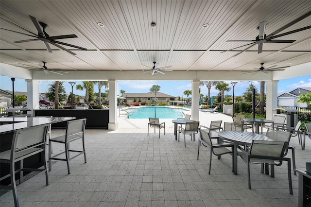 view of patio featuring a community pool and a bar