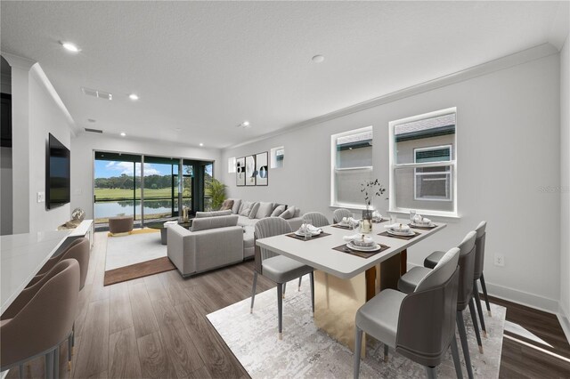 dining space with hardwood / wood-style flooring and crown molding