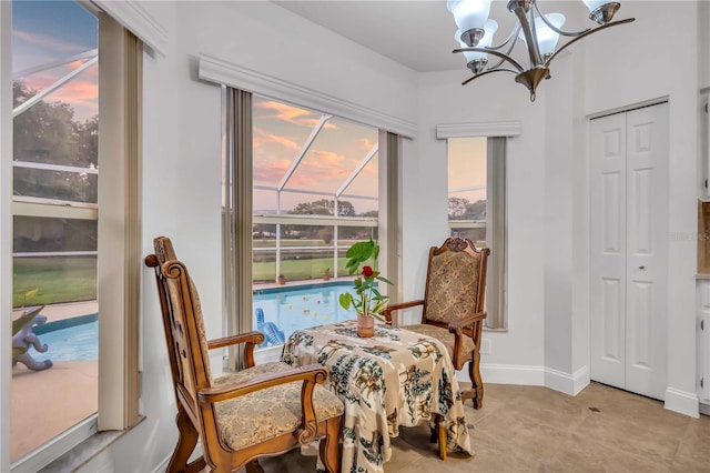 living area with light tile patterned floors, baseboards, and a chandelier