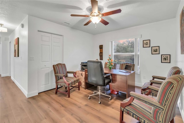 office area featuring visible vents, baseboards, wood finished floors, and a ceiling fan