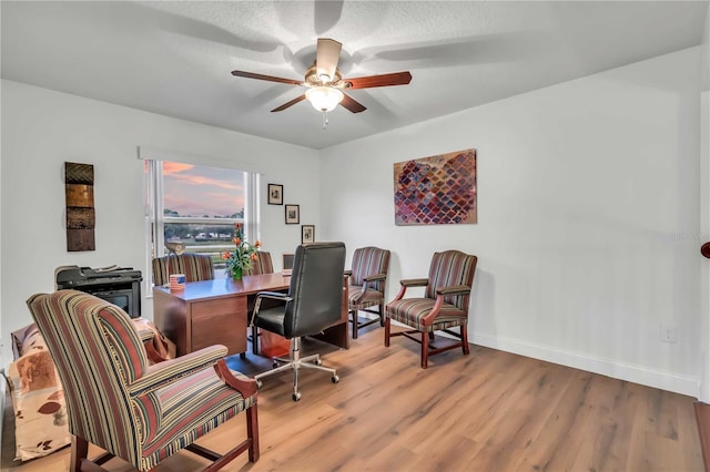 office space with wood finished floors, a ceiling fan, and baseboards