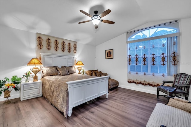 bedroom featuring light wood finished floors, a ceiling fan, baseboards, and vaulted ceiling