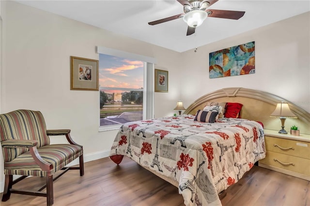 bedroom with ceiling fan, baseboards, and wood finished floors