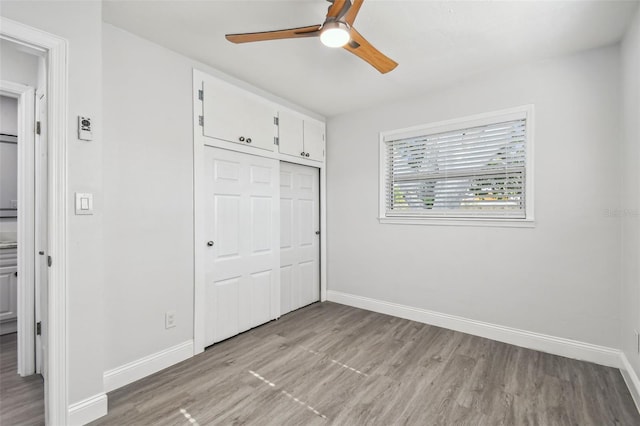 unfurnished bedroom with a closet, light hardwood / wood-style flooring, and ceiling fan