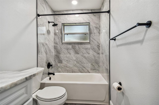 full bathroom featuring vanity, tiled shower / bath combo, and toilet