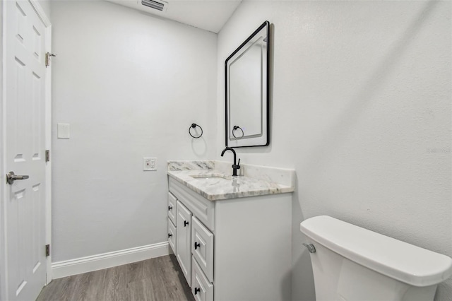 bathroom featuring hardwood / wood-style floors, vanity, and toilet