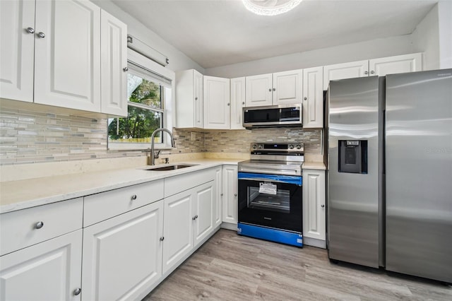 kitchen with white cabinets, backsplash, sink, and stainless steel appliances