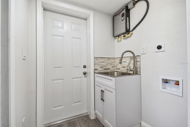 clothes washing area with sink, cabinets, dark wood-type flooring, hookup for an electric dryer, and hookup for a washing machine