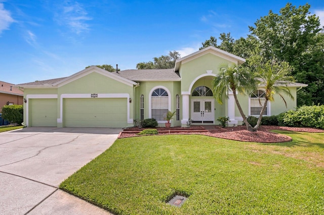 mediterranean / spanish house featuring a garage and a front lawn