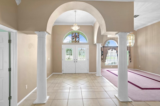 tiled foyer entrance featuring crown molding, french doors, and decorative columns