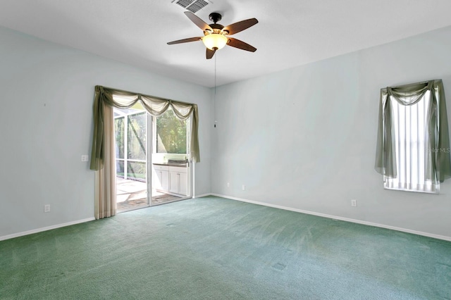 carpeted spare room featuring ceiling fan