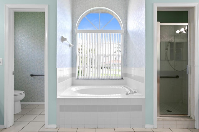 bathroom with tile floors, separate shower and tub, and toilet