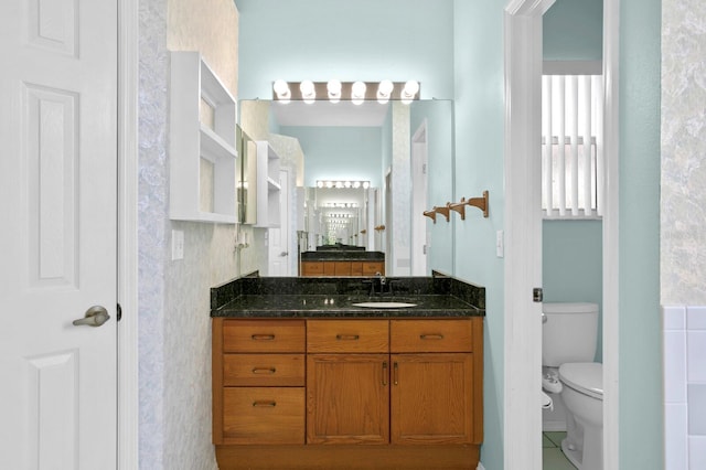 bathroom featuring tile flooring, vanity, and toilet