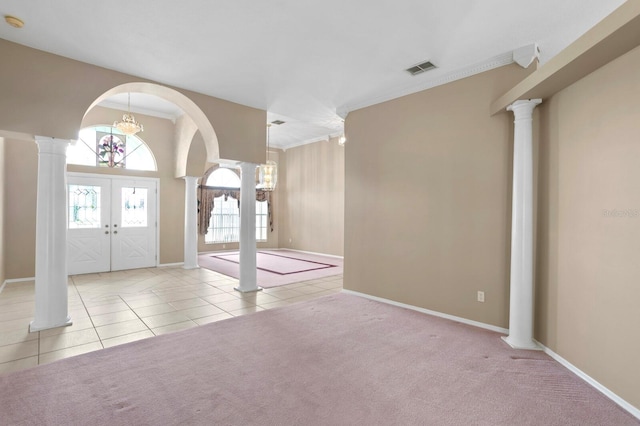 entryway featuring light carpet, french doors, ornamental molding, and ornate columns