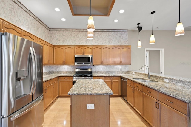 kitchen featuring light hardwood / wood-style flooring, stainless steel appliances, pendant lighting, light stone counters, and sink