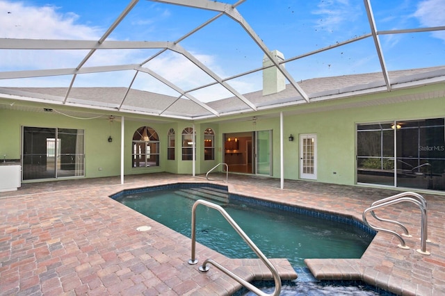 view of pool featuring a patio, ceiling fan, and glass enclosure