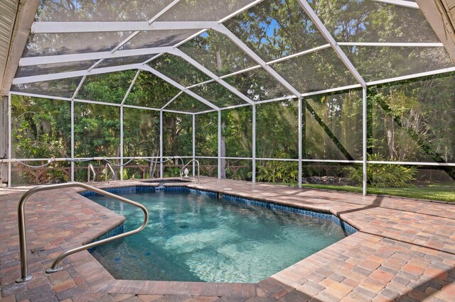 view of pool with glass enclosure and a patio area