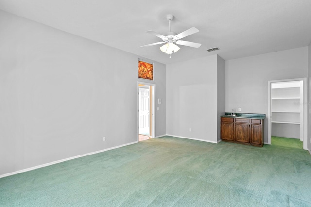 carpeted spare room with ceiling fan