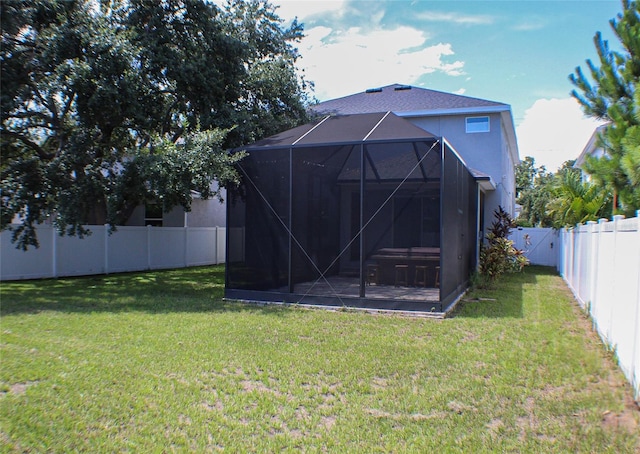 back of property with a yard and a lanai