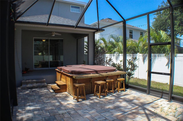 sunroom featuring ceiling fan and bar