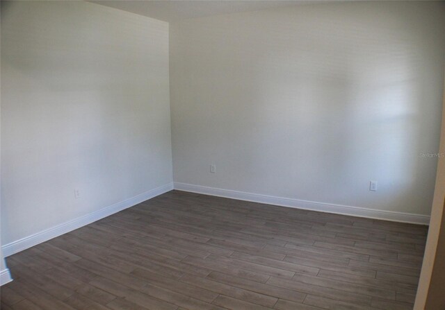 empty room with dark hardwood / wood-style flooring