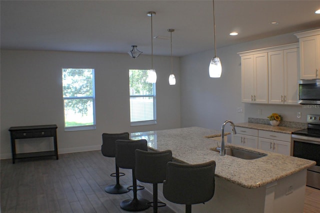 kitchen with sink, a center island with sink, stainless steel appliances, and light hardwood / wood-style floors