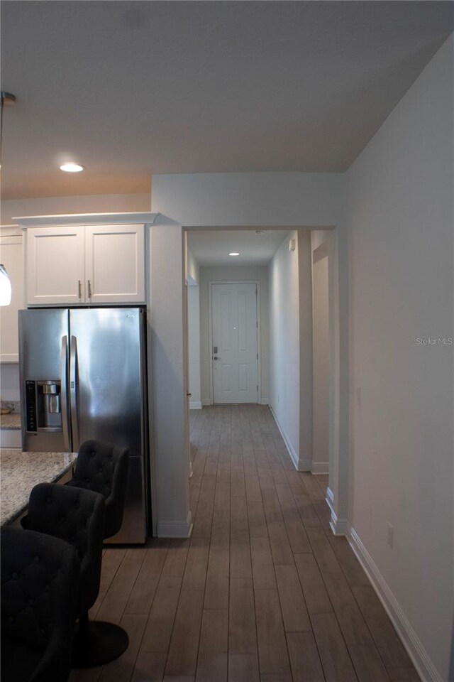 kitchen featuring white cabinets, stainless steel fridge, and wood-type flooring