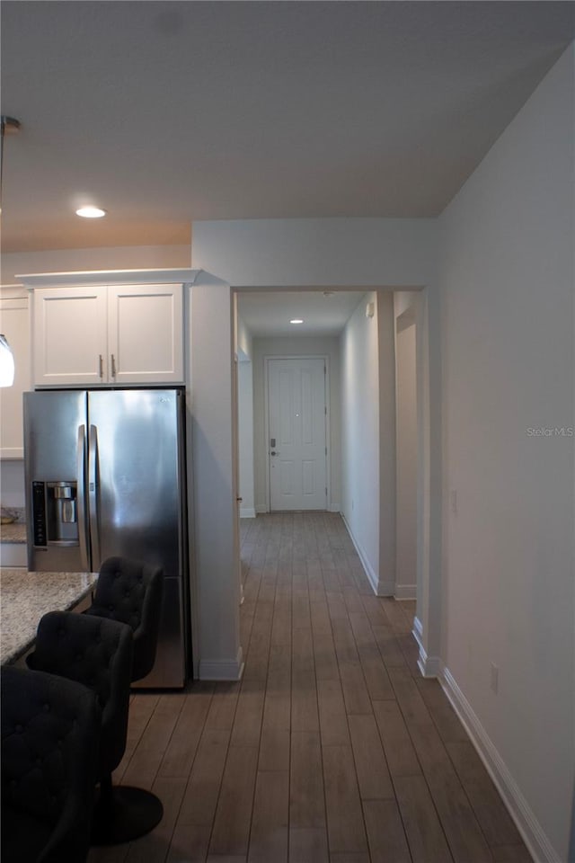 kitchen with light wood-type flooring, white cabinets, and stainless steel refrigerator with ice dispenser