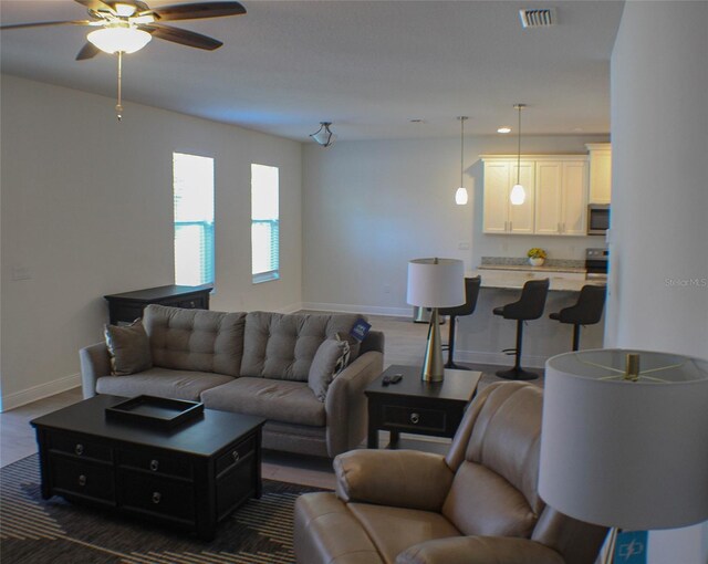 living room featuring dark hardwood / wood-style floors and ceiling fan