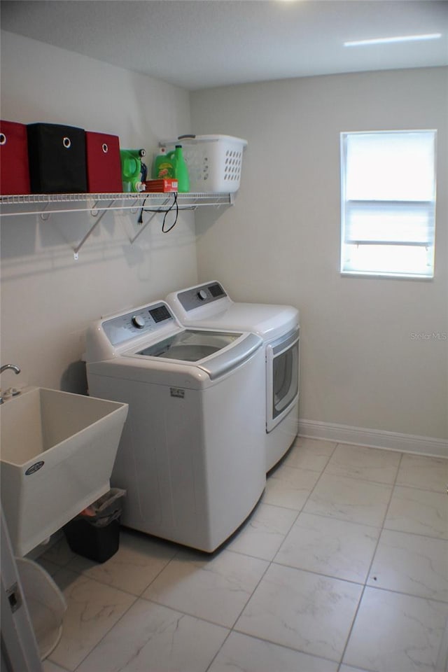 clothes washing area featuring separate washer and dryer and sink