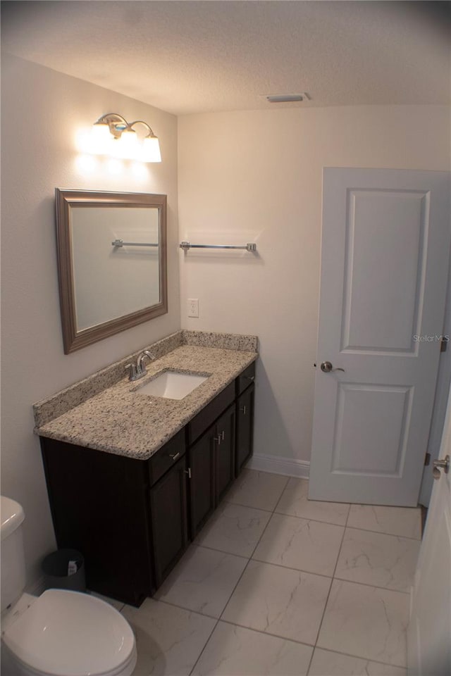 bathroom with vanity, tile patterned flooring, and toilet