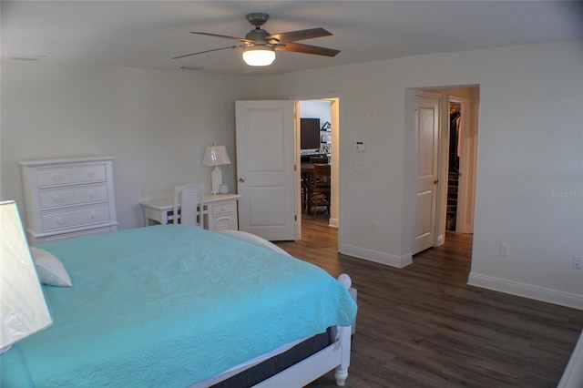 bedroom featuring ceiling fan, a walk in closet, and dark hardwood / wood-style flooring