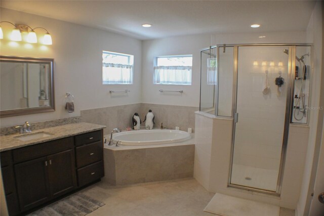 bathroom with tile patterned flooring, shower with separate bathtub, and vanity