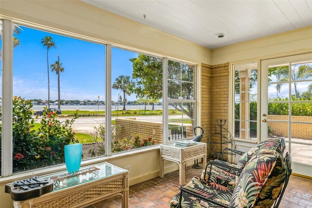 sunroom with a water view and wood ceiling