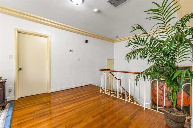 interior space with ornamental molding and hardwood / wood-style floors