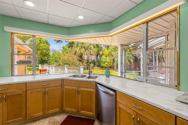 kitchen featuring dishwasher, sink, light tile floors, and a drop ceiling