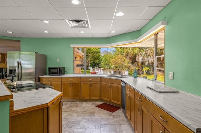 kitchen with sink, light tile flooring, and stainless steel appliances