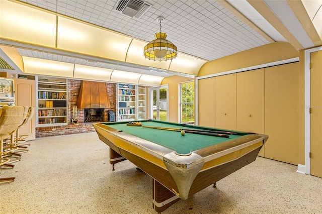 game room with brick wall, a brick fireplace, built in features, and billiards