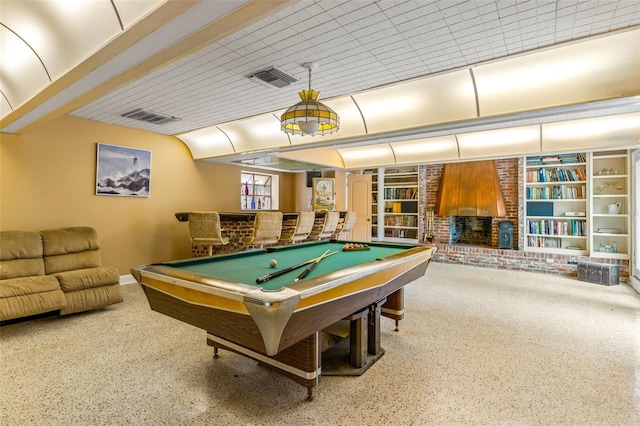 game room with brick wall, built in features, and billiards