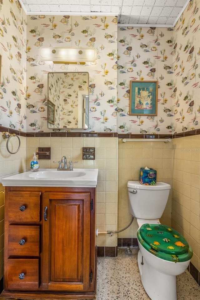 bathroom featuring tile walls, toilet, vanity, and tasteful backsplash