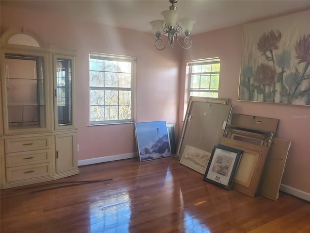 entryway featuring baseboards, a chandelier, and dark wood-style flooring