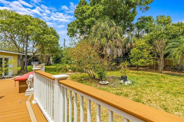 wooden terrace featuring a lawn