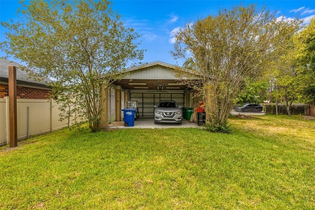 exterior space with a detached carport, fence, and driveway