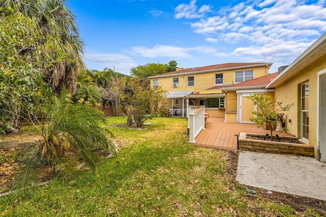 back of property featuring a deck, a yard, and a pergola