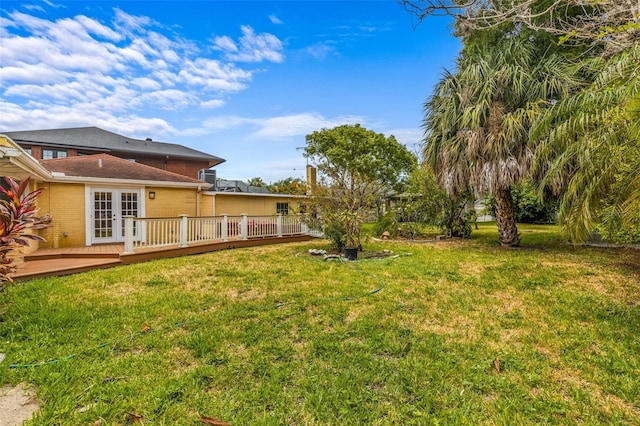 view of yard featuring french doors and a wooden deck